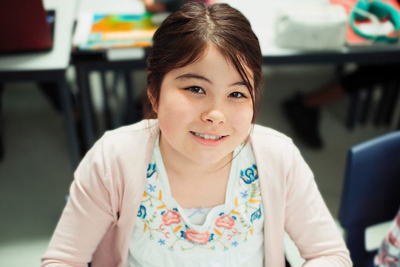 Elementary aged student working on a laptop.